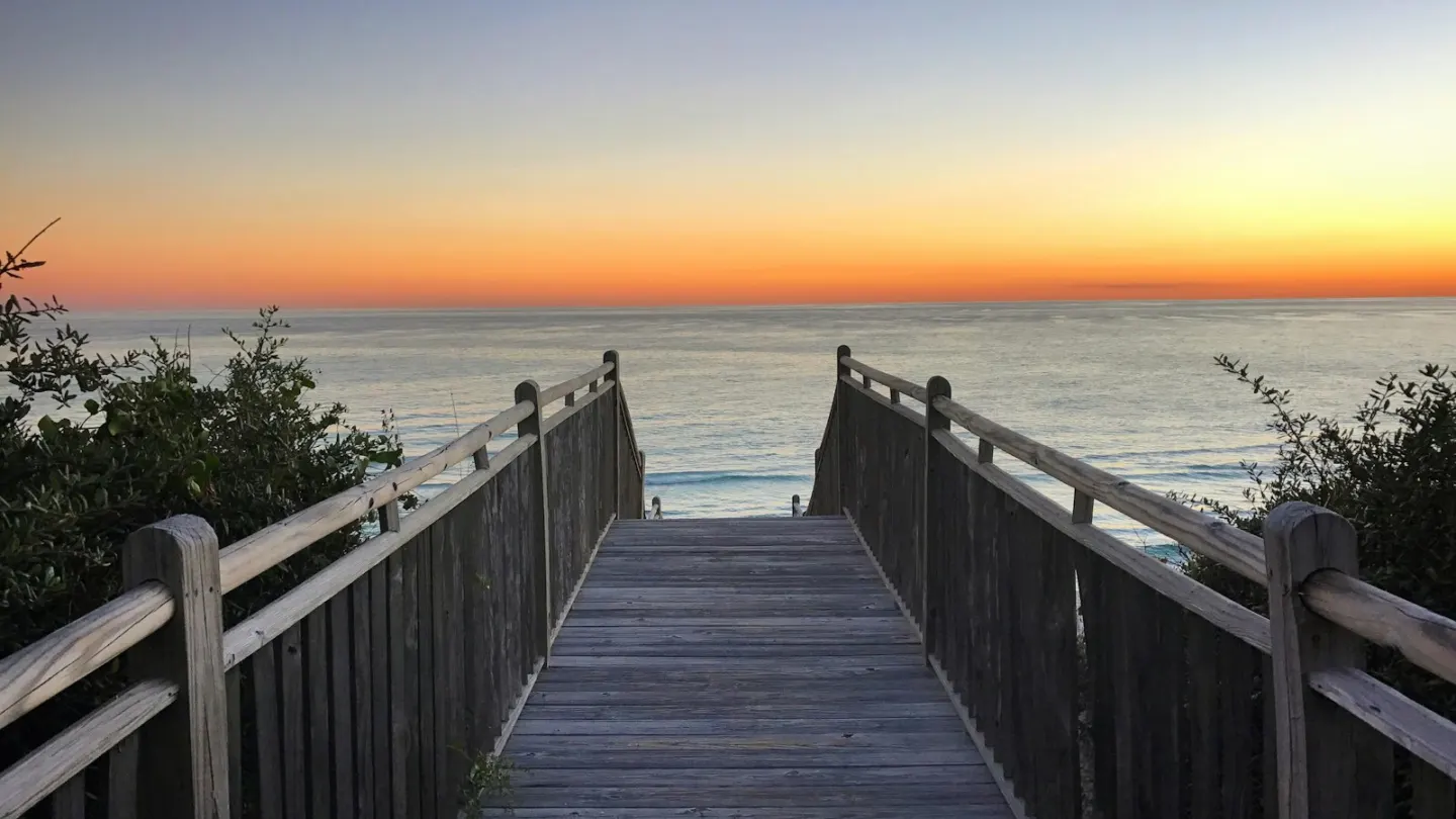 brown wooden dock on sea during sunset