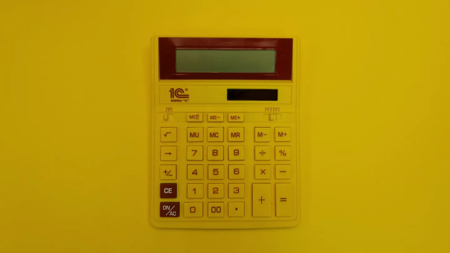 a calculator mounted on a yellow wall